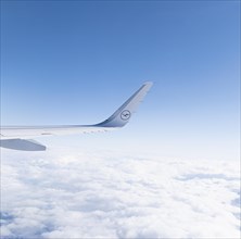 View of the wing of a Lufthansa aircraft over a sea of clouds