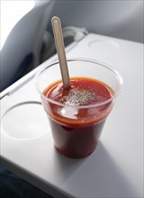 Tomato juice on a fold-out table in an aeroplane