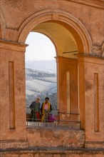 Couple smiling at camera through archway in Portico di San Luca