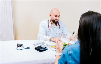 Nutritionist man giving consultation to woman patient in office