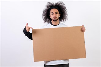 Pointing to a sign with copy paste space. Young man with afro hair on white background