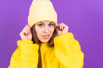 Close up portrait of young caucasian woman in yellow sweater isolated on yellow background