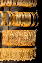 Shop display of dozens of golden bracelets and bangles