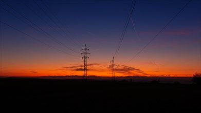 High voltage poles standing on the background of the blue hour. Czech republic
