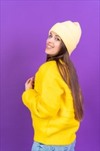Close up portrait of young caucasian woman in yellow wool sweater isolated on yellow studio background