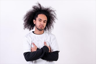 Portrait with arms crossed looking. Young man with afro hair on white background