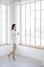 Attractive woman in a white shirt in front of a window