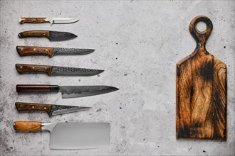 Different kinds of knives and wooden cutting board