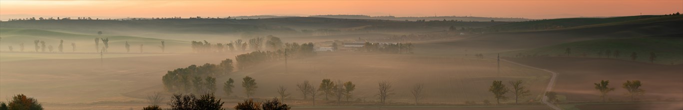 A wonderful large panorama of green Moravian fields shrouded in morning fog. Czech republic