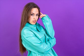 Close up portrait of young caucasian woman in blue trench coat isolated on purple studio background