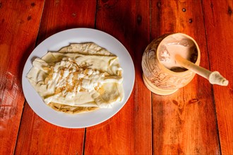 Delicious traditional Quesillo with cocoa drink. Quesillo plate with cocoa drink served on wooden table. Typical Nicaraguan food and drinks