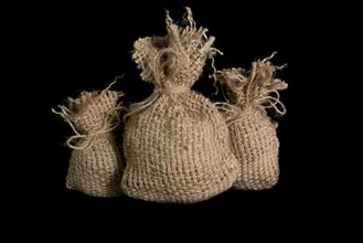 A small jute bag on a black background. In studio