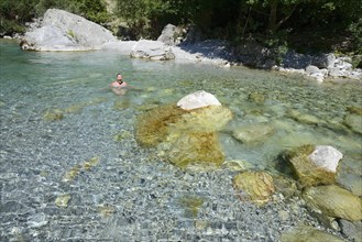 Woman bathing in the cold water of the Valbona