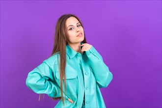 Close up portrait of a young caucasian woman in blue trench coat isolated on purple background