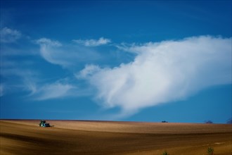 Work with an agricultural tractor in Moravian fields. A wonderful blue sky. Czech Republic