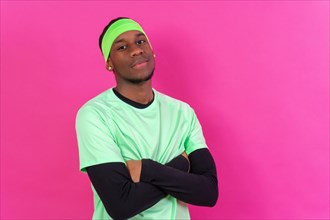 Black ethnic man in green clothes on a pink background