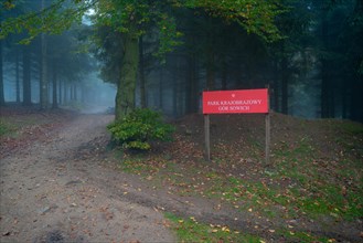 Entrance to the landscape park. Foggy and humid weather in the background. Polish mountains