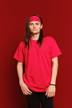 Three quarter portrait of positive guy wearing red band on head and t-shirt