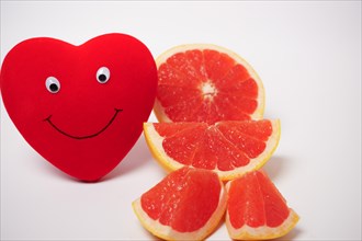 Smiling heart with a cut grapefruit healthy food concept