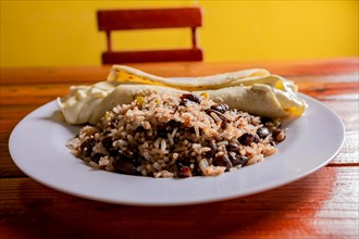 Gallo pinto with Quesillo served on wooden table. Nicaraguan gallopinto with quesillo on the table. typical nicaraguan foods