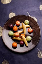 Plate with fruits made of marzipan on a blue blanket