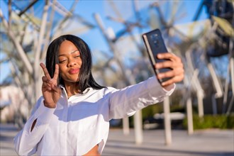Young african woman in white clothes in the city at sunset