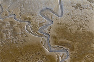 Aerial view of stream running through tidal mudflat at the Schleswig-Holstein Wadden Sea National Park