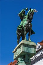 Bronze figure of the Postmichel on top of the Postmichel fountain in Fischbrunnenstrasse