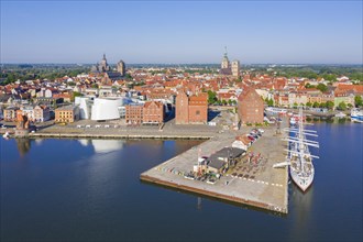 Aerial view over public aquarium Ozeaneum and three-mast barque Gorch Fock docked in harbour of the city Stralsund