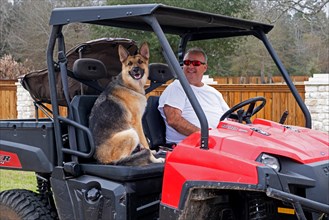 Man with German shepherd dog in Polaris Ranger 500 EFI utility task vehicle