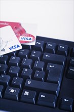 Debit card on a computer keyboard. Paying bills and internet shopping