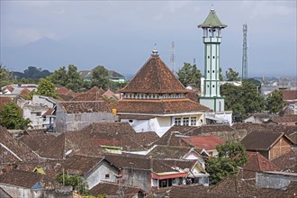 Aerial view over red roofed kampung houses and old mosque with minaret in the city Malang