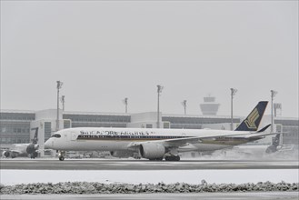 Singapore Airlines aircraft in winter in front of Terminal 2 with tower