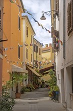 Pastel colored alley with restaurants in the town Izola