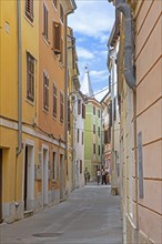 Alley with pastel coloured houses in the town Izola