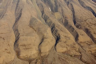 Aerial view of barren mountainside with deep gullies carved by water erosion at Spitsbergen
