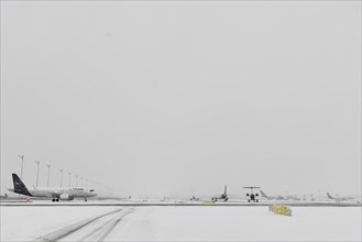 Aircraft in wait for de-icing and take-off clearance in winter snow flurry
