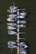 Aerial view over berthing jetty with sailing boats at marina in harbour of the city Stralsund along the Strelasund