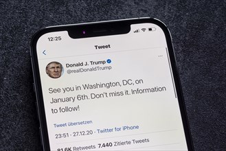 Smartphone with a Twitter tweet from Donald Trump with a message about his conspiracy theories