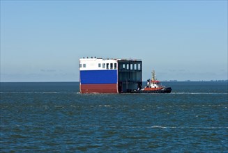 Tugboat with a ship section on the Lower Elbe near Cuxhaven
