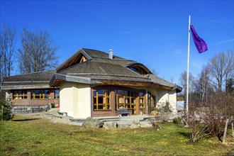 Main building with flagpole and flag on the grounds of the free school Albris