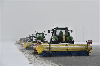 Snow clearing machines and snow removal tractors clearing snow on the apron Cargo