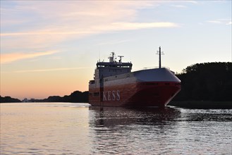 Cargo ship KESS sailing at sunrise in the Kiel Canal