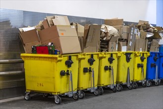 Full yellow waste containers with waste paper and cardboard