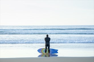 A male surfer contemplating the ocean in La Jolla