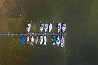 Aerial view over sailing boats moored at wooden jetty in lake Ratzeburger