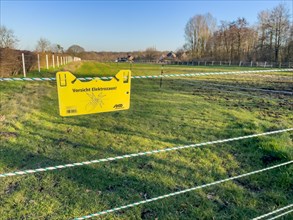 Warning sign on electric fence in wolf area Schermbeck