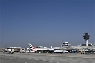 Iberia Airbus with Sunexpress Boeing B737 and Emirates Airbus A380-800 in front of Terminal 1 with Tower