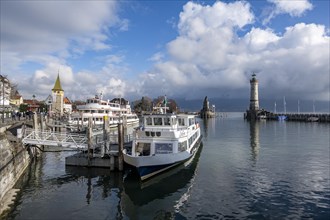 Passenger boats in Lindau harbour, behind harbour entrance with New Lindau Lighthouse and Bavarian Lion, Lindau Island, Lake Constance, Bavaria, Germany, Europe
