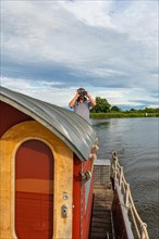 Man With Binoculars on a House Raft, Pension Havelfloss, Brandenburg an der Havel, Havelland, Brandenburg, Germany, Europe